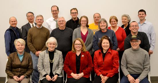 A group of people of varying ages all sitting and smiling at the camera