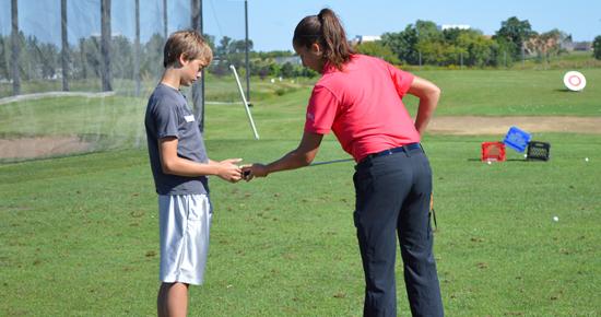 Woman teaching a youth golf techniques