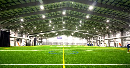 Vast indoor space with green artificial turf.