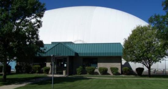 The golf dome with a building in front of it