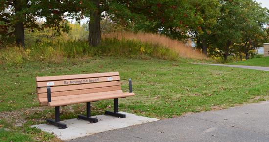 A memorial bench off of a park trail