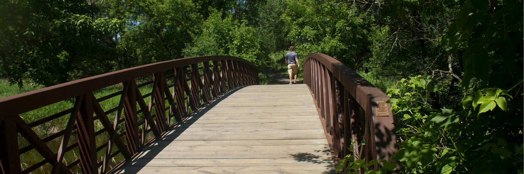 A Ramsey County Trail with a wooden bridge
